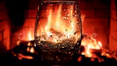 在壁炉背景下缓慢地将白葡萄酒从瓶子倒入酒杯中，葡萄酒的美丽库存镜头